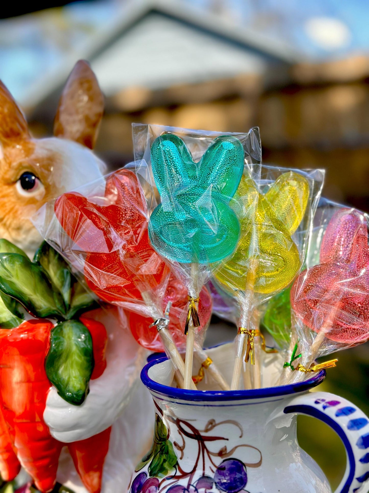Colorful bunny lollipops arranged in a white ceramic pitcher